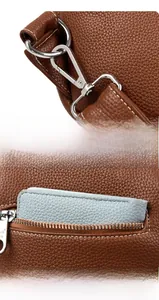 Detail of brown lychee grain leather crossbody bag with silver hardware and back zip pocket