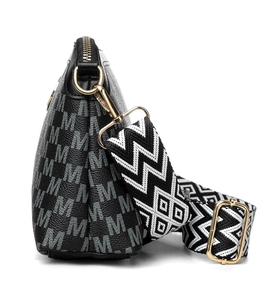 Detail of black crossbody bag with white M-pattern print and colorful jacquard strap