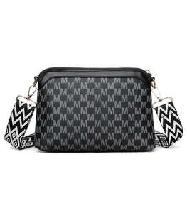 Close-up of retro printed crossbody bag with golden hardware and wavy pattern strap