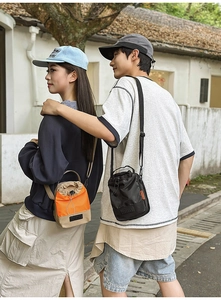 Outdoor shot of models wearing compact crossbody drawstring bags for couple styling