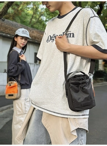 Detail of waterproof nylon crossbody bag with drawstring closure and utility patch
