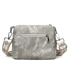 Detail of grey crossbody bag featuring a wide embroidered strap and metallic zipper pocket