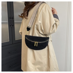Detail of black suede waist bag with ethnic style woven strap and golden zipper