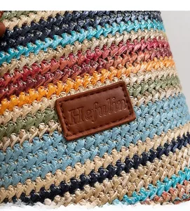 Close-up of colorful striped woven texture and premium leather label on a crossbody bag