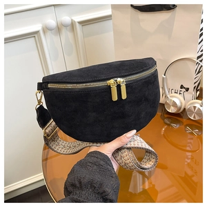 Detail view of black suede crescent waist bag with gold zippers and bohemian wide strap