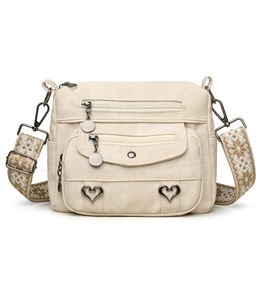 Detail of beige canvas crossbody bag featuring heart buckles and star embroidered strap