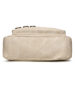 Side view detail of light beige canvas shoulder bag with silver metal rings and fine stitching