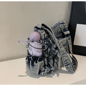 Détail du sac bandoulière en jean vintage avec poches zippées et poche latérale pour parapluie