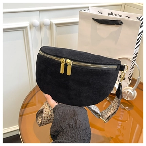 Detail of black suede waist bag with gold double zippers and embroidered strap