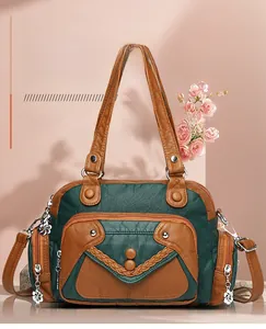 Detail of vintage green and brown soft leather handbag showing multiple zipper pockets