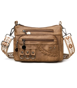 Close-up of vintage brown leather bag with multi-zipper pockets and jacquard strap