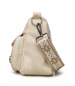 Detail view of beige canvas crossbody bag with jacquard strap and side flap pocket