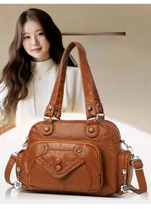 Detail of soft leather handbag with woven trim and floral metal zipper pulls