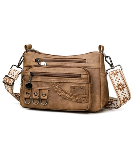 Detail of vintage brown PU leather crossbody bag with ethnic patterned shoulder strap