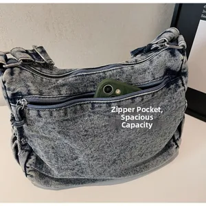 Vue détaillée du sac bandoulière en denim spacieux avec plusieurs poches zippées et compartiments