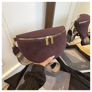Detail of burgundy suede crescent bag with gold zippers and ethnic embroidery strap