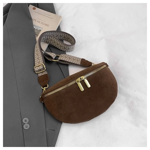 Detail of dark brown suede fanny pack with golden zippers and geometric woven strap