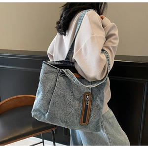 Vue détaillée du grand sac cabas en denim délavé avec poche zippée en cuir marron