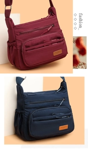 Detail of crossbody bag showing multiple functional zipper pockets and adjustable straps