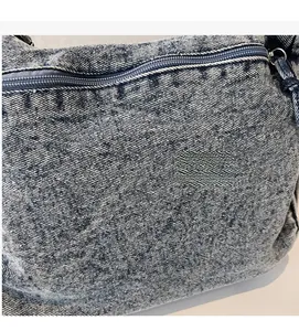 Détail de la texture en denim bleu et de la fermeture éclair du sac à bandoulière multicouche