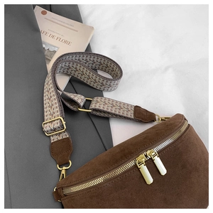 Detail of dark brown suede fanny pack with ethnic woven strap and gold hardware