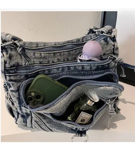 Détail de l'intérieur du sac en jean bleu montrant plusieurs poches et une grande capacité
