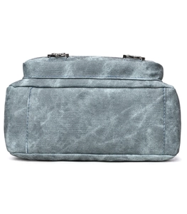 Close-up of dark grey denim texture bag with blue stitching and metal buckles