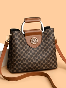 Gros plan détaillé du sac rétro monogrammé avec anneaux en métal et poignée en cuir
