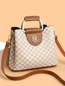 Vue latérale détaillée du sac bandoulière beige à monogramme avec poignée ronde et rabat brun