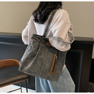 Détails du cabas en denim lavé avec touches de cuir marron et poche zippée latérale