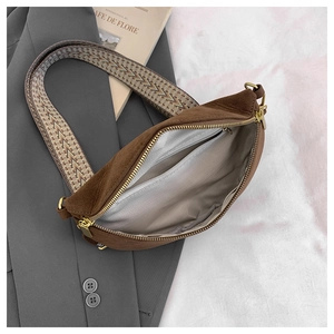 Detail view of brown suede crossbody bag with geometric strap and inner zipper pocket