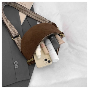 Detail of brown crescent bag showing interior space and ethnic style wide strap