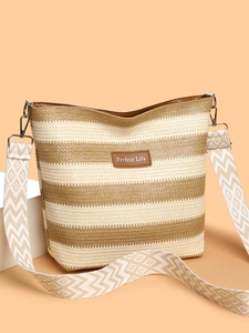 Detailed close-up of striped woven tote bag featuring embroidered strap and leather logo