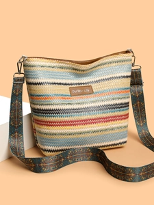 Detail of colorful striped woven tote bag with leather logo patch and geometric wide strap