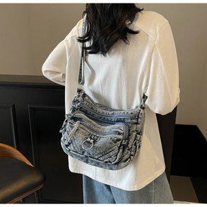 Détails du sac bandoulière vintage en denim bleu avec plusieurs fermetures éclair