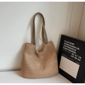 Detail of hand-woven straw tote bag with natural texture and reinforced shoulder straps