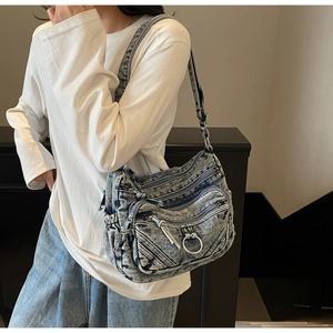 Détails du sac bandoulière en denim délavé bleu vintage avec poches zippées et anneau en métal