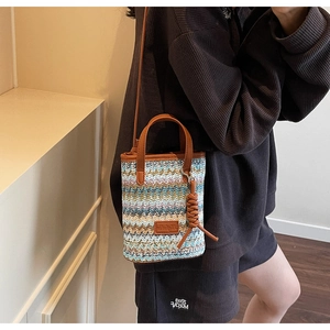 Detail of colorful wave pattern woven bag with brown leather trim and shoulder strap
