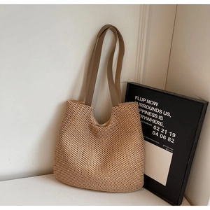 Close-up of natural woven straw texture and durable fabric straps on a large tote bag