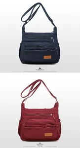 Detail view of multi-pocket nylon crossbody bags in blue and wine red colors