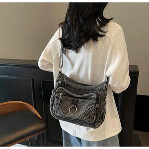 Vue arrière d'un mannequin portant un sac bandoulière multipoches en denim noir