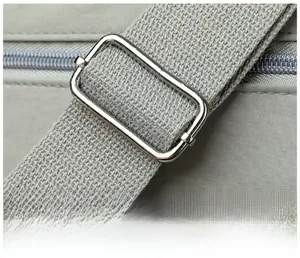 Detail of adjustable metal buckle and durable gray strap on a minimalist shoulder bag
