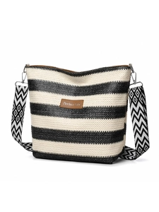 Close-up of woven crossbody bag with black white stripes and wide geometric strap