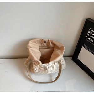 Detail of hand-woven tote bag showing mesh pattern, fabric lining, and magnetic silver clasp