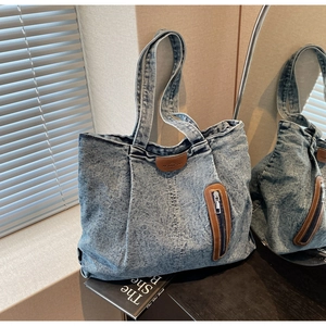 Vue détaillée du sac cabas en jean délavé avec étiquette en cuir et poche zippée