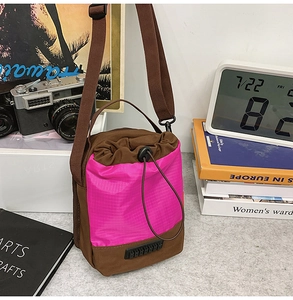 Detail of a brown and pink drawstring crossbody bag styled with vintage lifestyle props