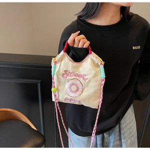 Détail de la broderie Sweet rose et du motif donut sur un mini sac en toile crème