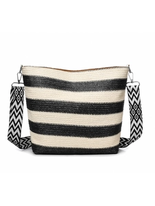 Detail of woven straw tote bag with black and white stripes and geometric wide strap