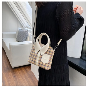 Detail van de geel geruite crossbodytas met een creatief overhemdkraagontwerp en knopen