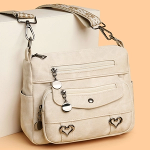 Minimalist beige canvas crossbody bag with multiple zip pockets and jacquard strap